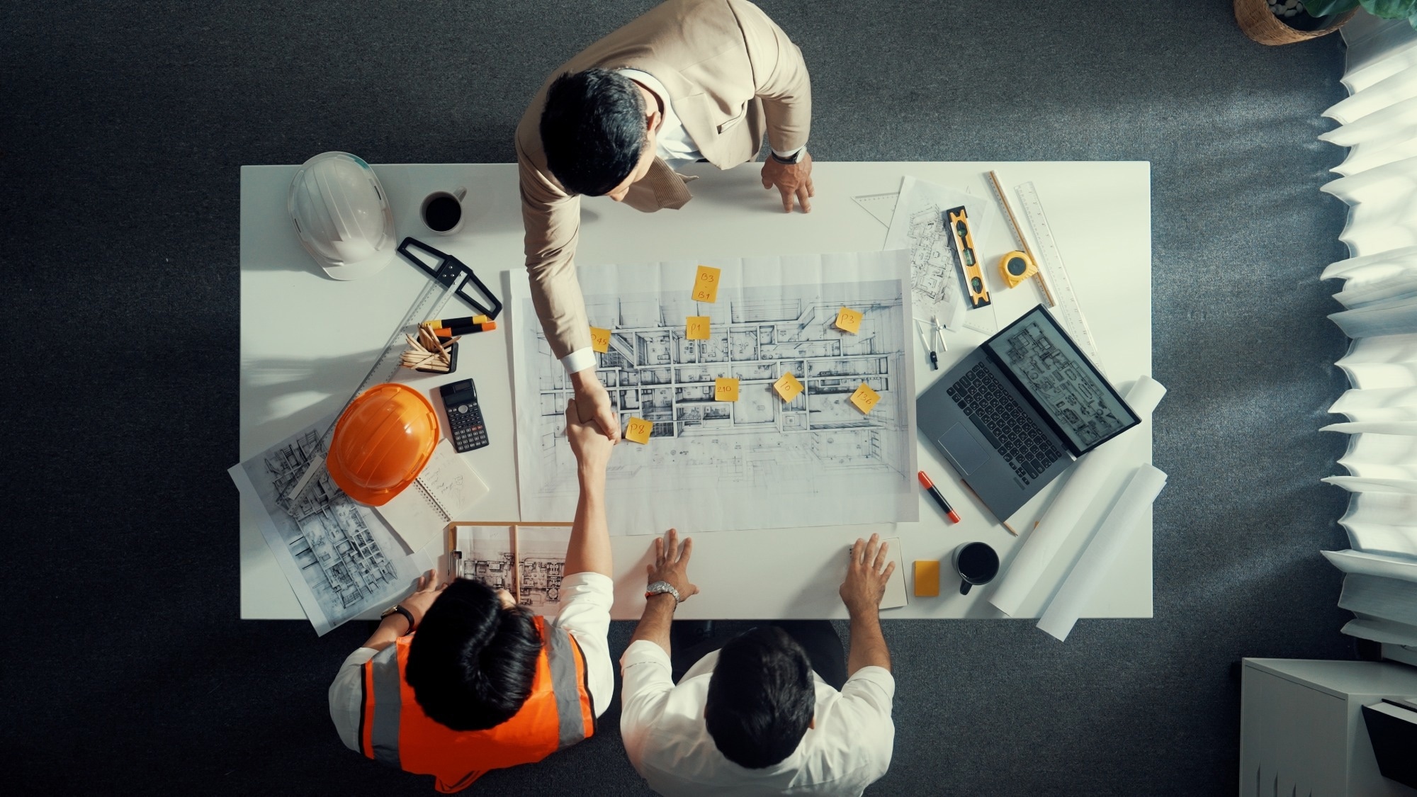 Top down aerial view of an architect and engineer team discussing a construction project.