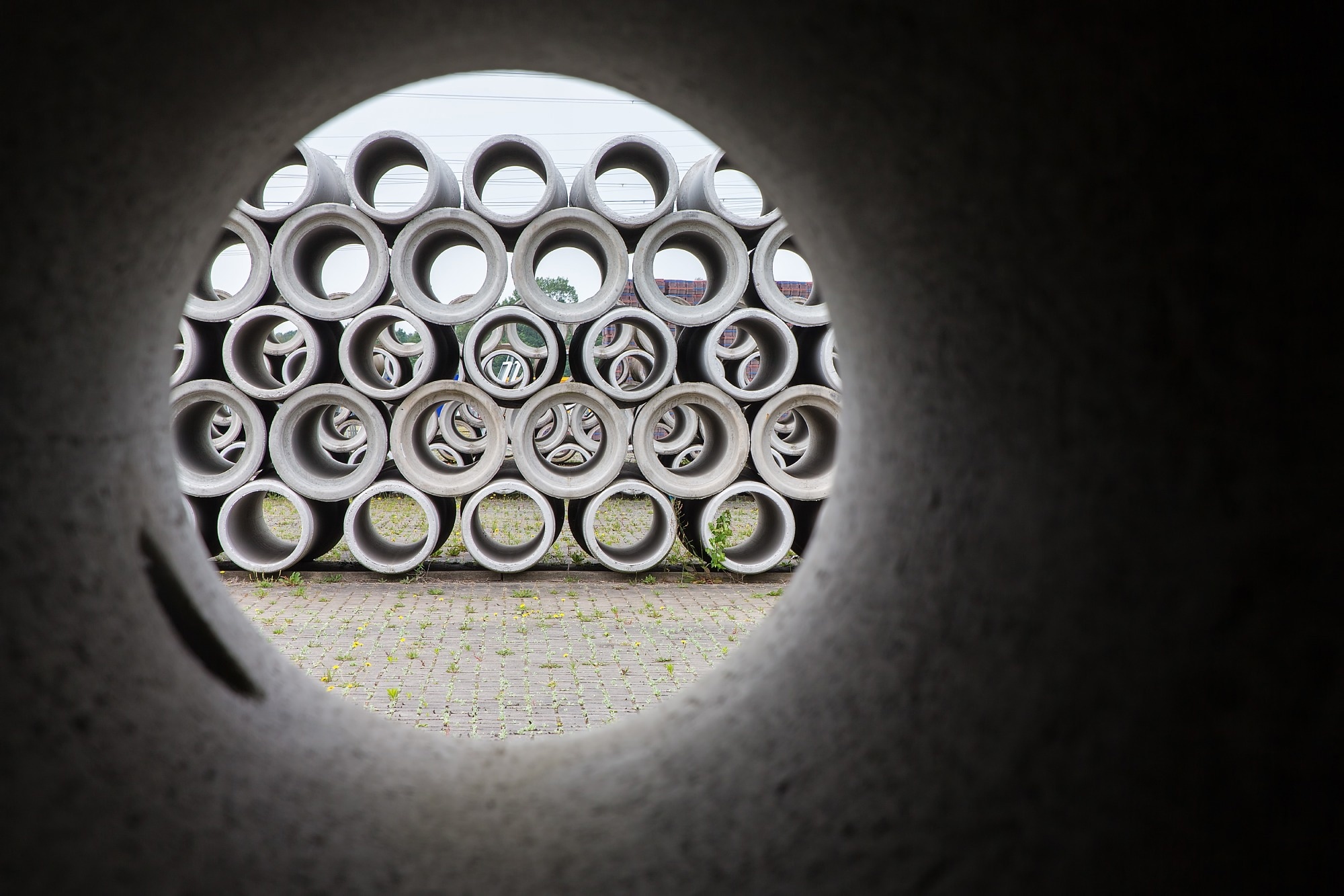 See-through with pile of concrete sewer pipes at concrete plant.