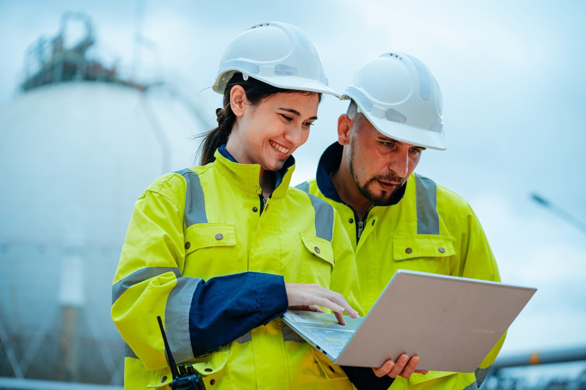 Man and women in the construction industry looking at a construction plan on a laptop.