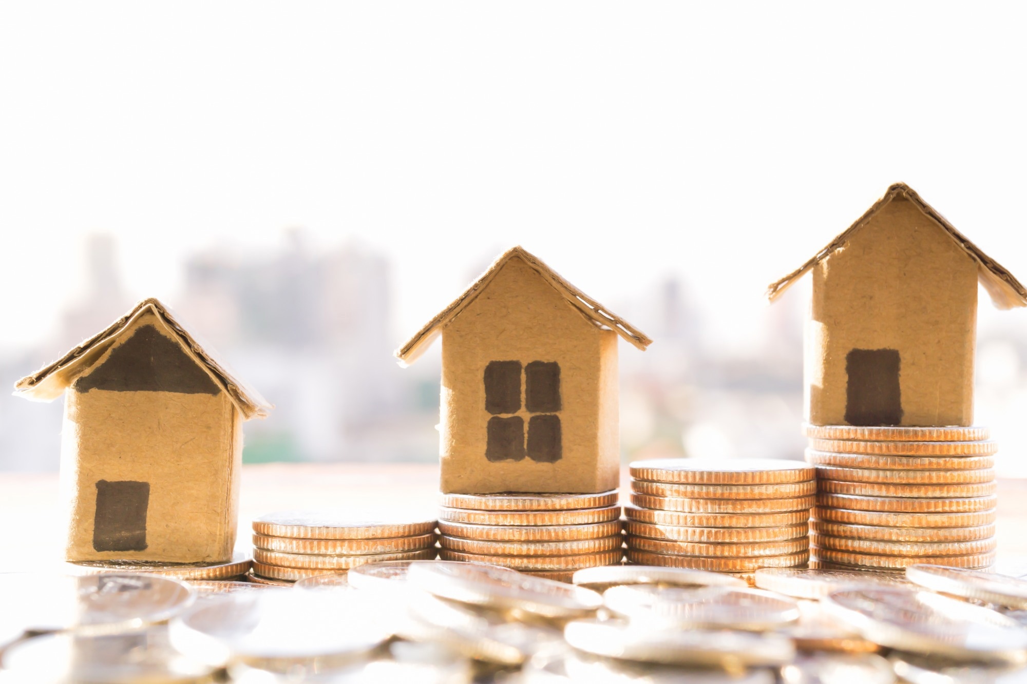 Miniature houses with coins in front