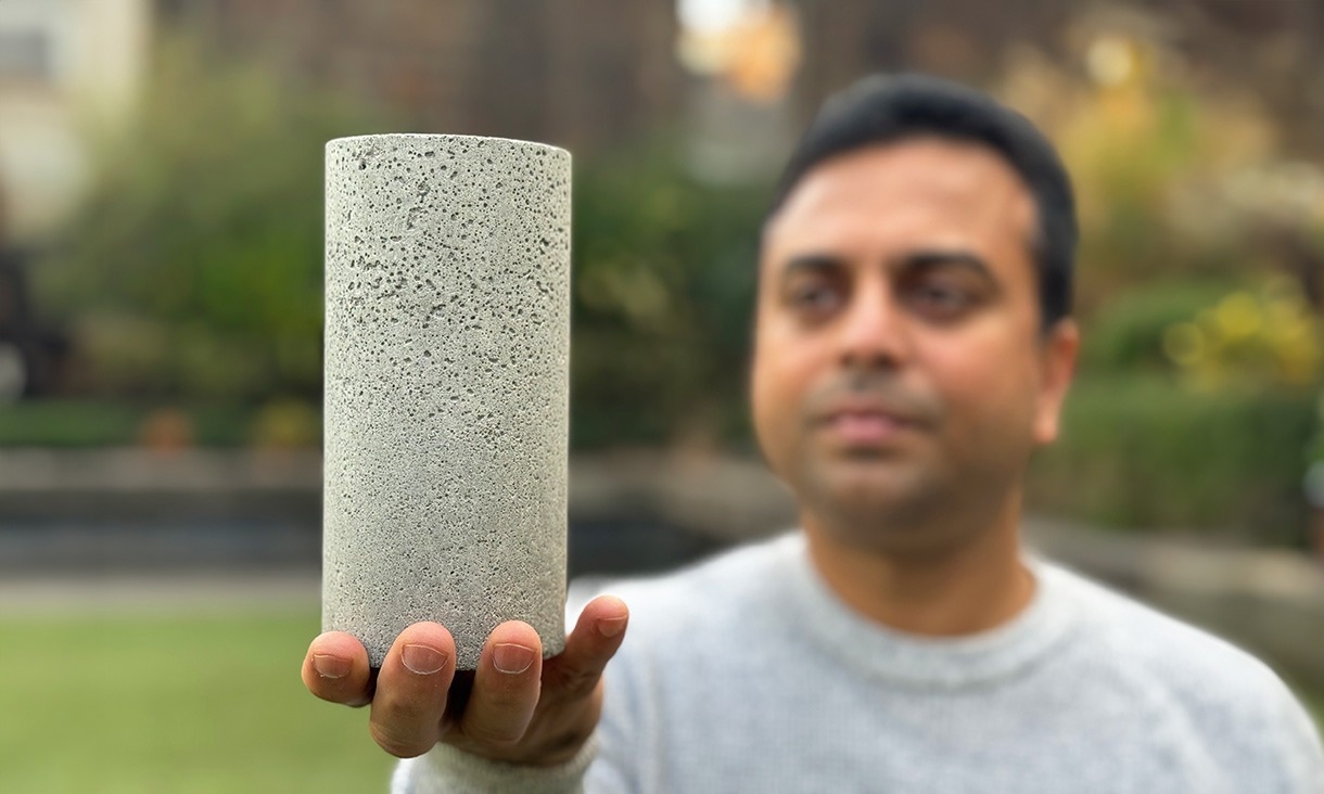 Dr. Chamila Gunasekara holds a sample of the low-carbon concrete.