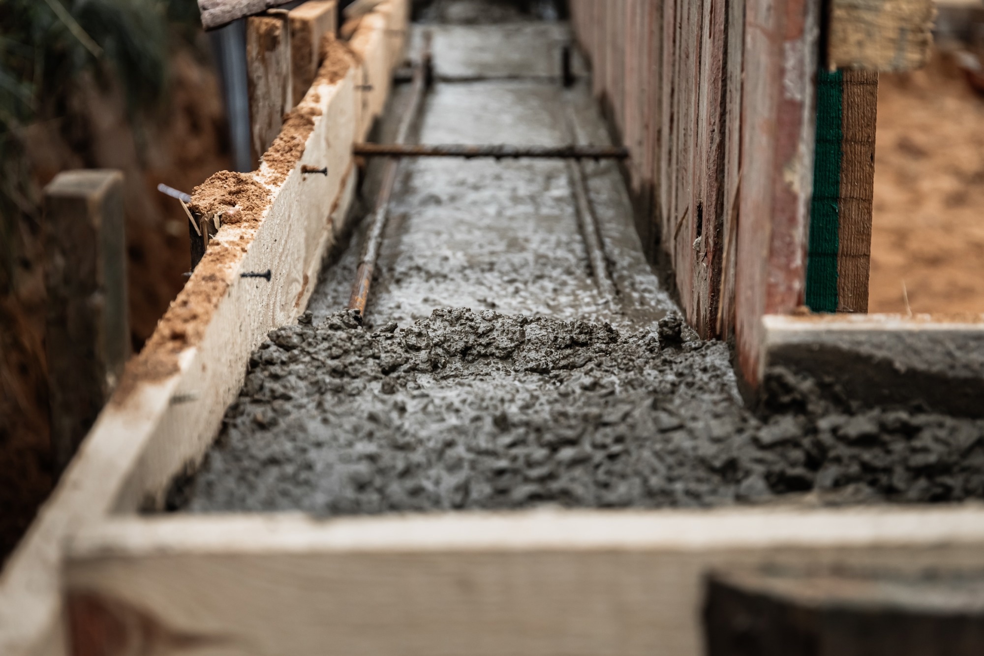 Timber formwork with metal reinforcement for pouring concrete and creating a solid foundation for a building or fence. Construction process.