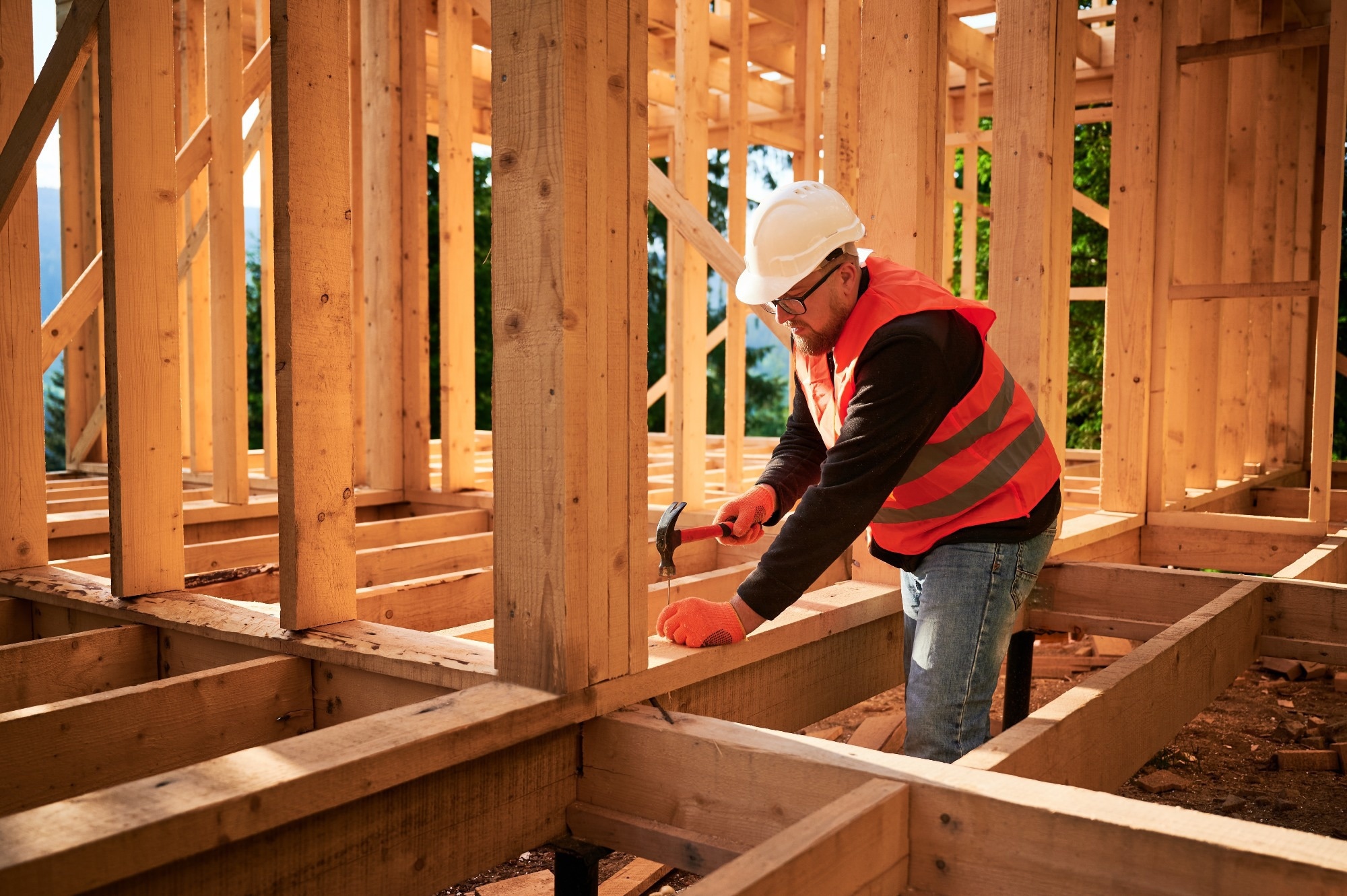 Carpenter constructing wooden frame house.