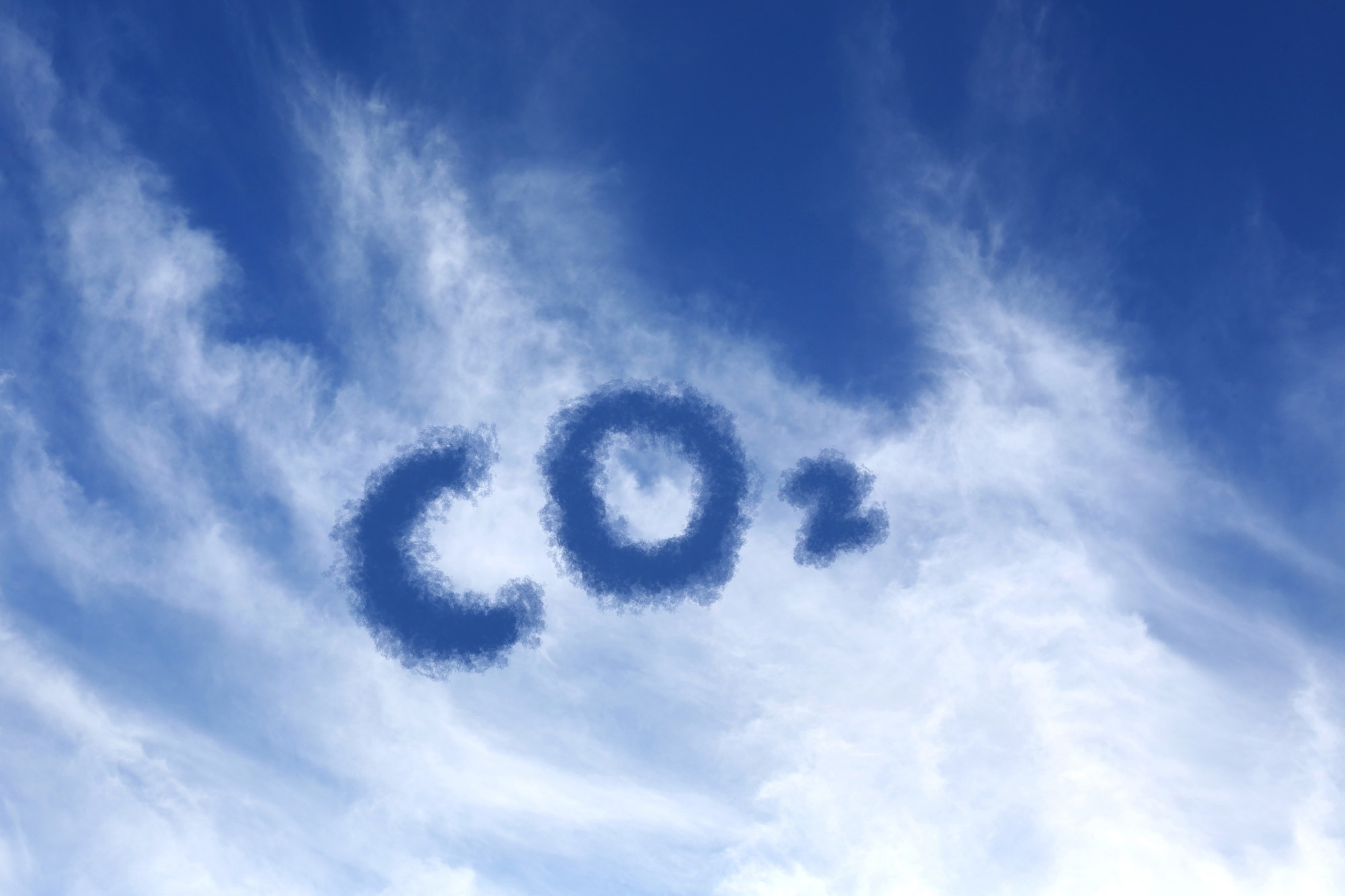 Blue sky with CO2 chemical formula and clouds.