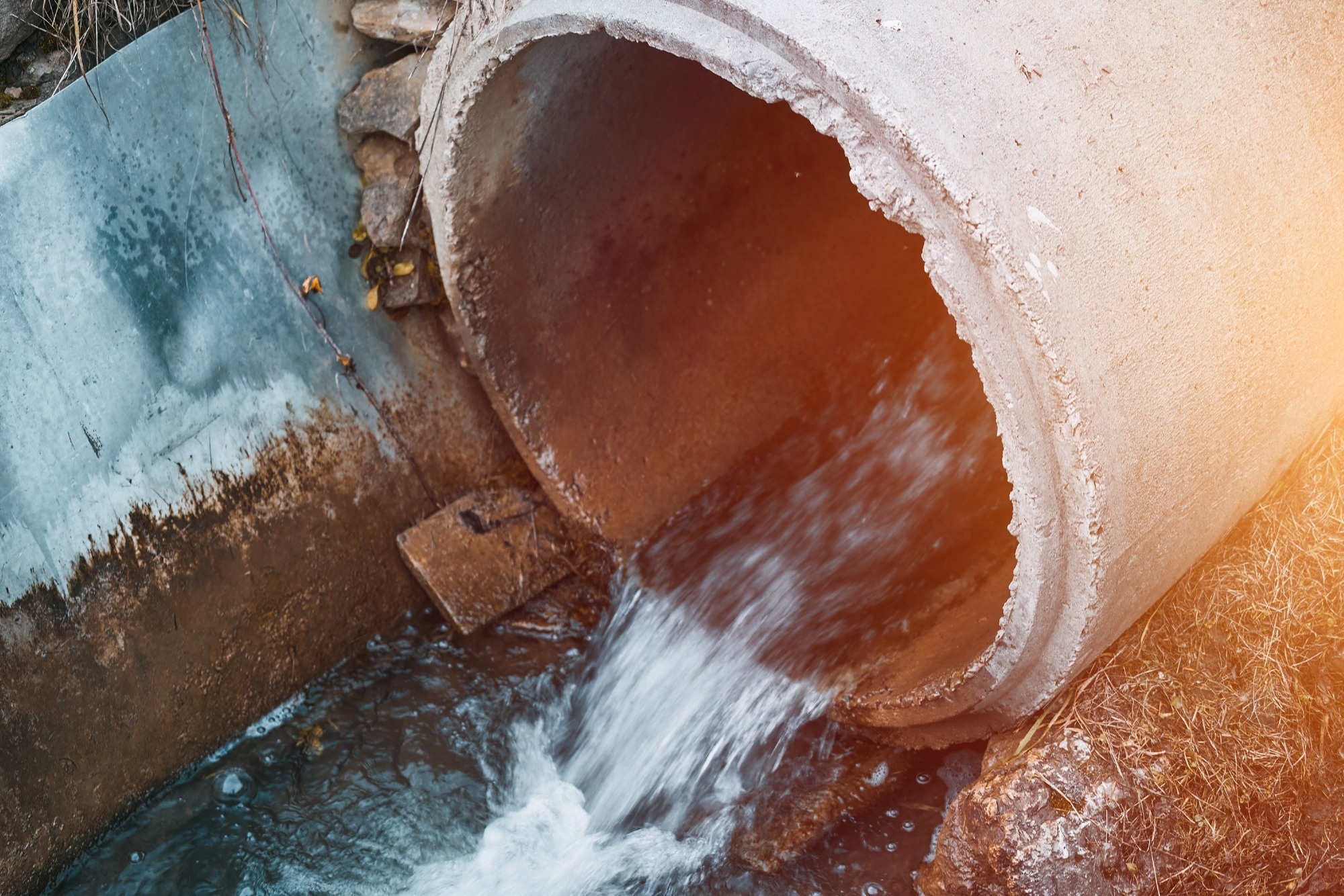 Draining sewage from a pipe into the river.