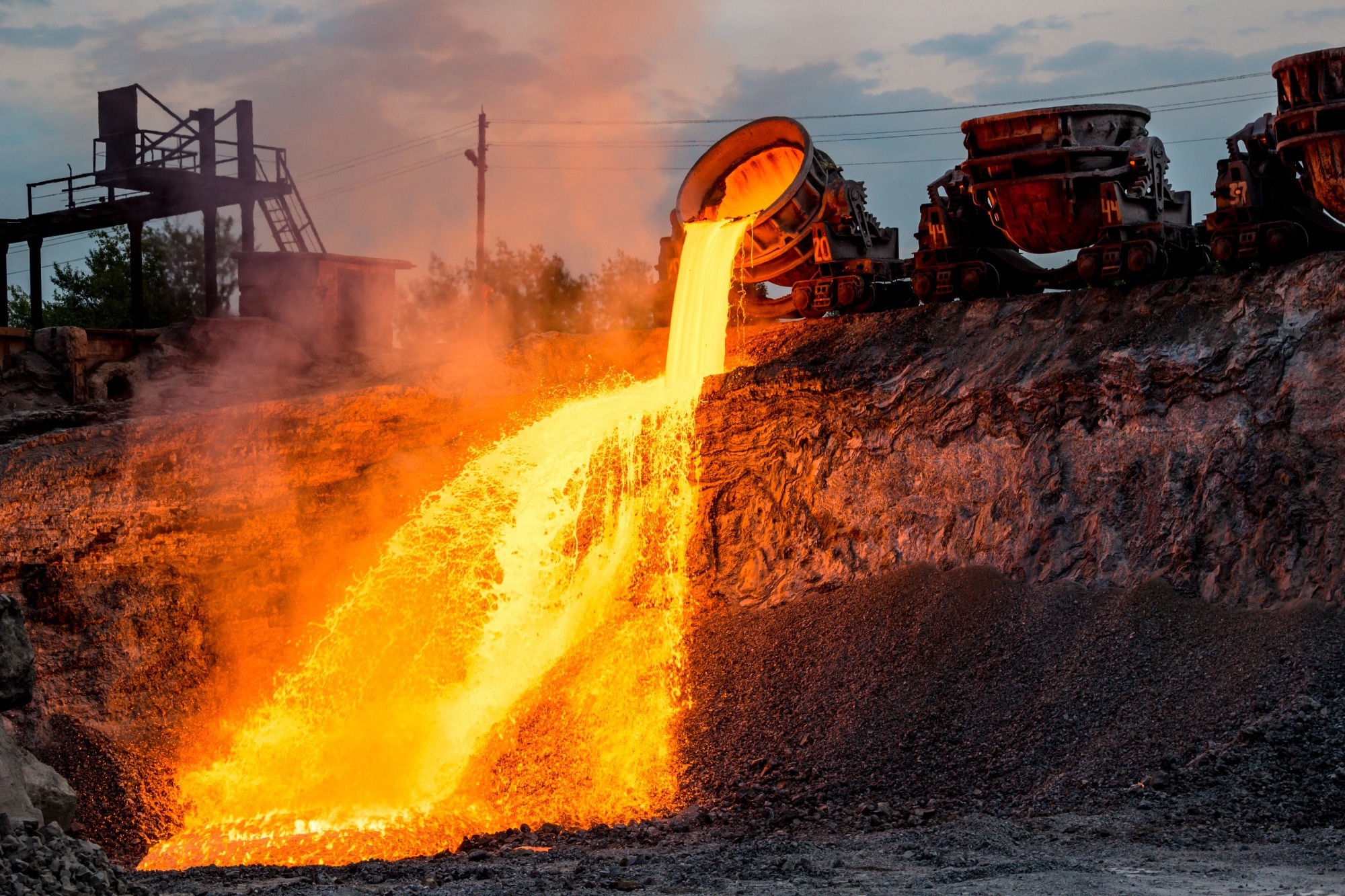 Blast furnace slag discharge at metallurgical plant, colorful hot lava flow, industrial landscape of iron foundry.