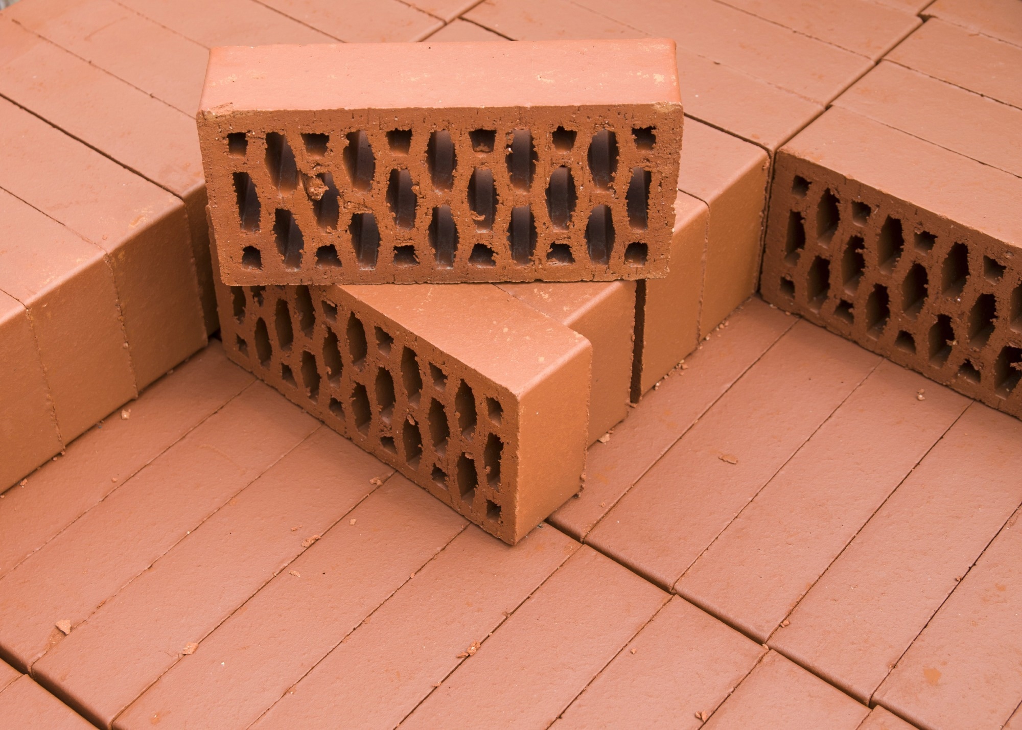 A stack of new red clay bricks in rows.