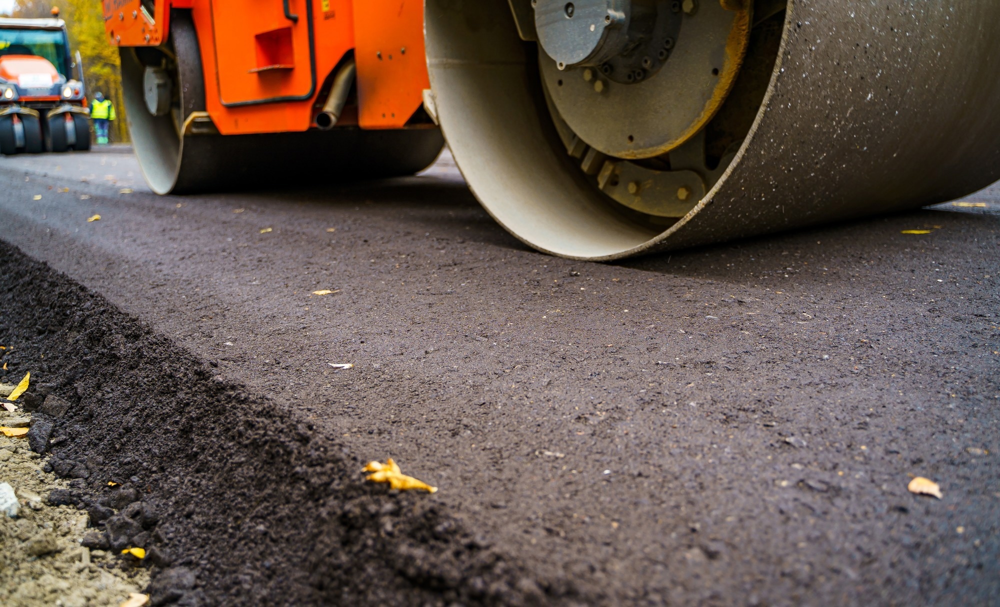 Heavy vibration roller at asphalt pavement works. Road repairing. Selective focus, cropped photo. New asphalt.