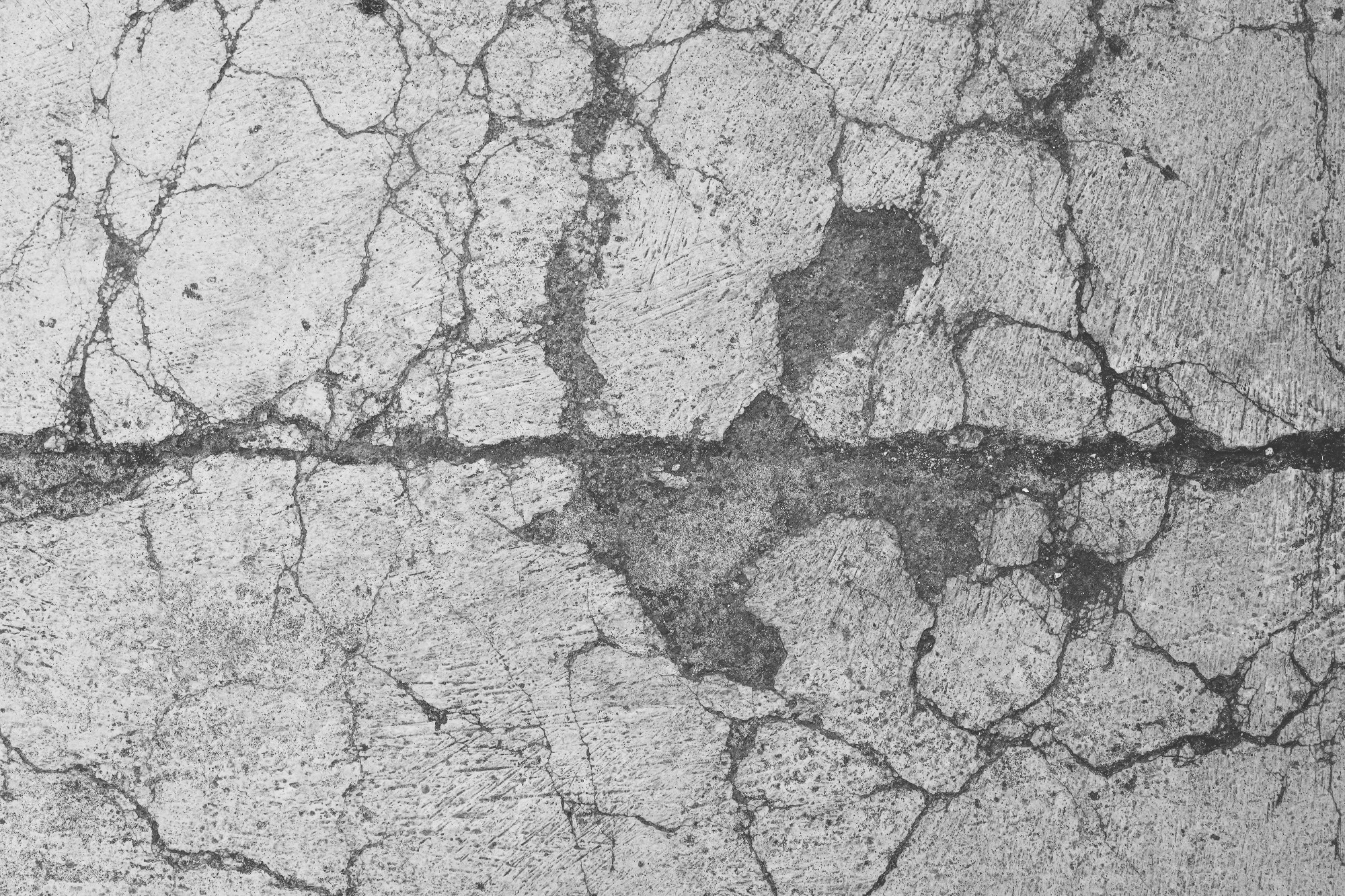 Close up of a cracked and broken concrete surface.