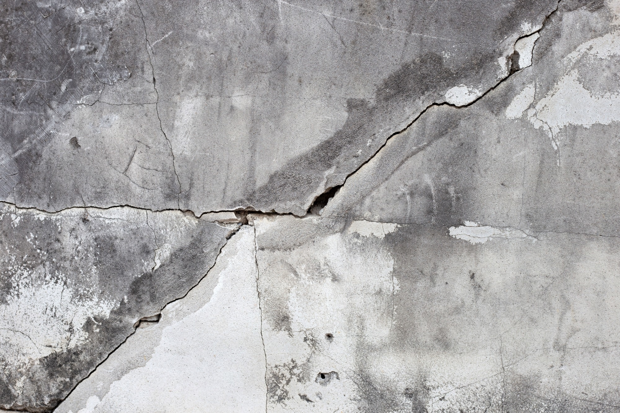 Cracked concrete wall, broken building structure.