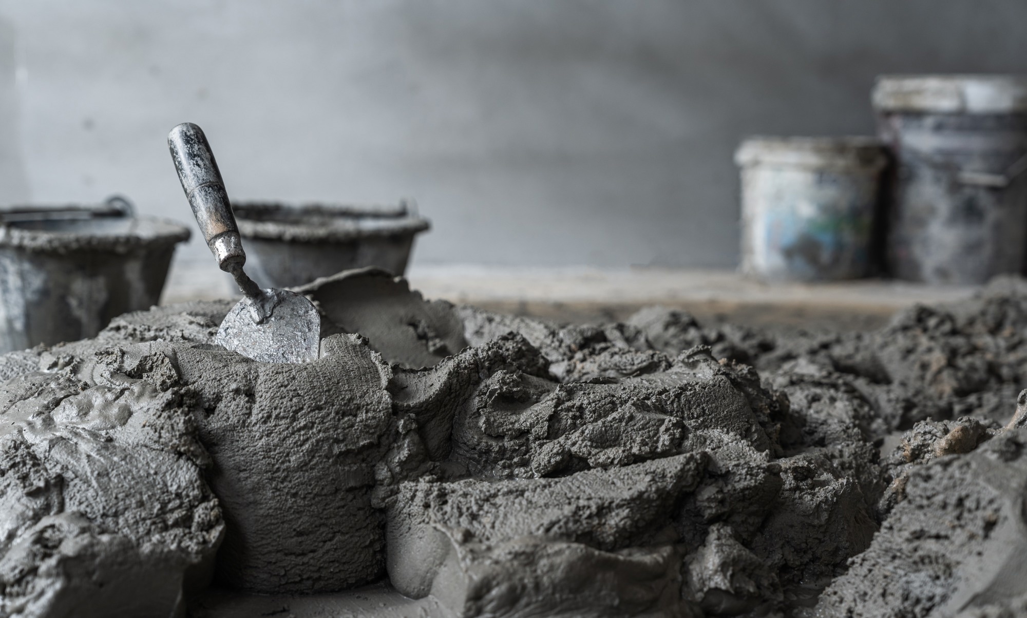 Cement mix with rough on concrete floor and trowel mixing prepare plaster concrete wall room.