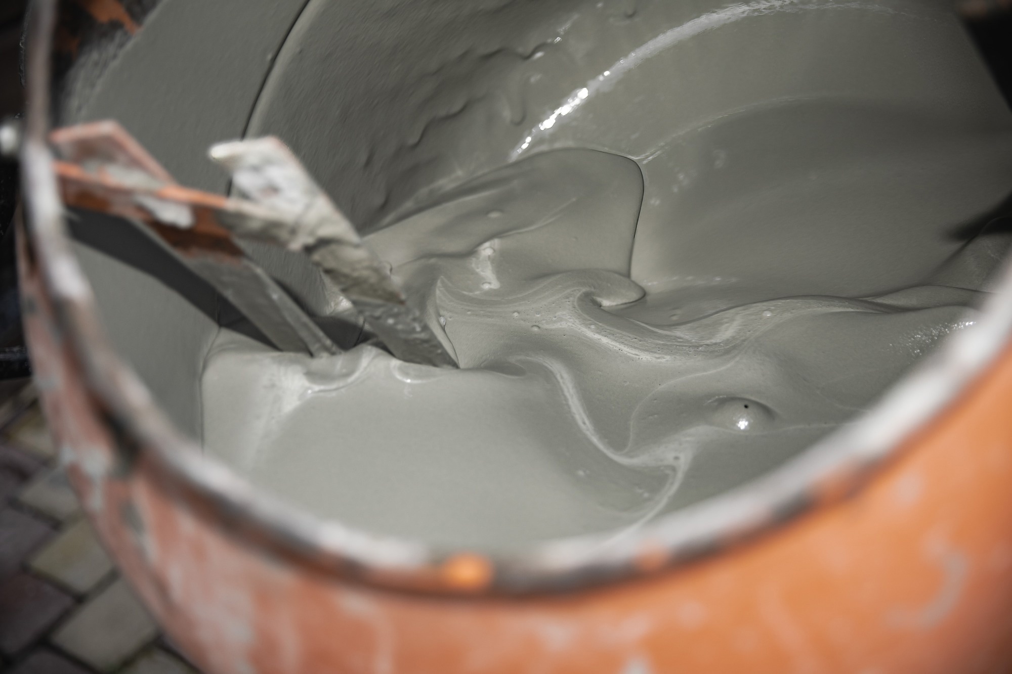 Fresh cement mixture inside concrete mixer drum close-up.