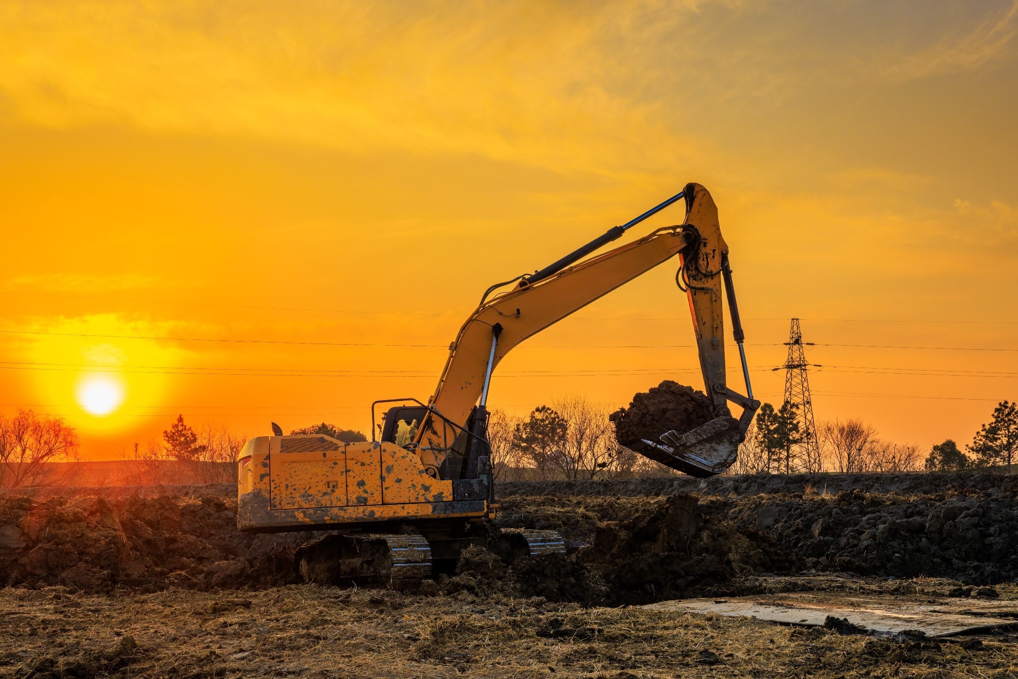 Heavy excavator working on a construction site during golden hour sunset