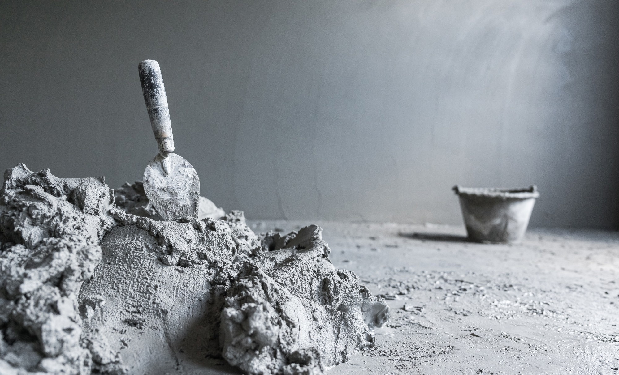 Cement Mortar mix with rough on concrete floor and trowel mixing prepare plaster concrete Portland wall room construction house site background and bucket with space blank for design text presentation